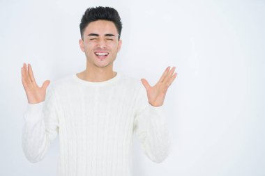 Beyaz izole arka plan üzerinde yakışıklı genç adam çılgın ve silah ile başarı için deli kutluyor kaldırdı ve heyecanlı çığlık kapalı gözleri. Kazanan kavramı