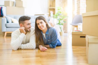 Yeni evin katında yatan genç güzel çift, gülümseyen 