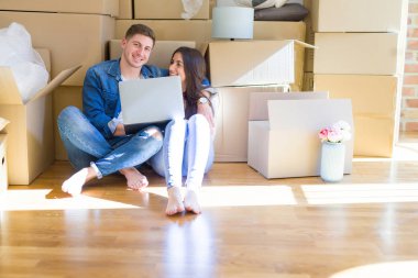 Karton etrafında yeni evin katında oturan genç çift 