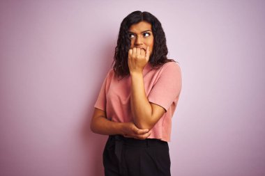 Izole pembe arka plan üzerinde Genç güzel transseksüel transseksüel zarif kadın ağız Tırnakısırma elleri ile stresli ve sinir görünümlü. Anksiyete sorunu.