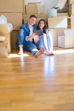 Karton etrafında yeni evin katında oturan genç çift 