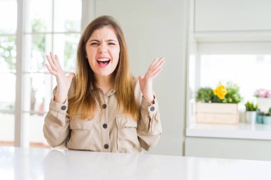 Güzel genç kadın evde deli ve deli bağırarak ve agresif ifade ve silah kaldırdı bağırıyor. Hayal kırıklığı kavramı.