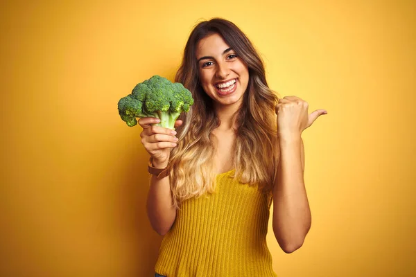 Genç Güzel Kadın Sarı Izole Arka Plan Üzerinde Brokoli Yeme — Stok fotoğraf