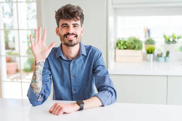 Hombre Joven Con Camisa Casual Sentado Mesa Blanca Mostrando Apuntando — Foto de Stock