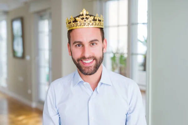 Handsome business man wearing golden crown as a king or prince with a happy and cool smile on face. Lucky person.