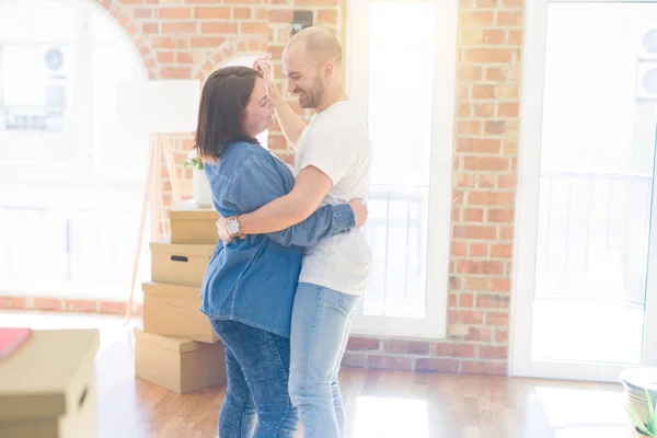 Pareja joven bailando alrededor de cajas de cartón en casa nueva, celebran — Foto de Stock