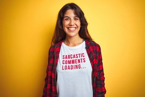 Beautiful woman wearing funny t-shirt with irony comments over isolated yellow background with a happy face standing and smiling with a confident smile showing teeth