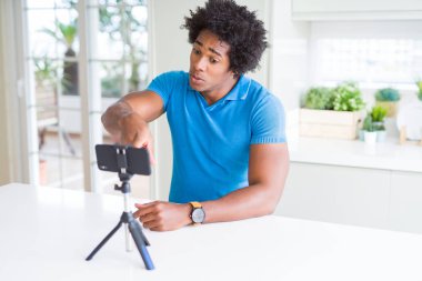Afro-Amerikan adam kamera ve size parmak ile işaret akıllı telefon kullanarak web kamerası ile online arama yapıyor, el işareti, önden olumlu ve kendinden emin jest