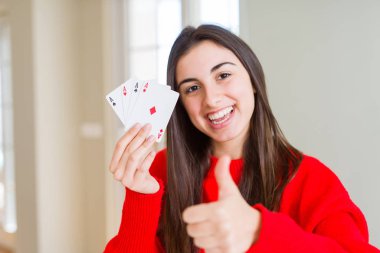 Güzel genç kadın kumar büyük bir gülümseme ok işareti yapıyor ile poker mutlu oynarken, parmakları ile başparmak, mükemmel işareti