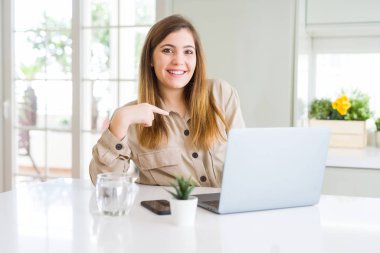 Güzel genç kadın kendini parmak işaret sürpriz yüzü ile bilgisayar dizüstü bilgisayar kullanarak