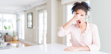 Afro saçlı güzel afro-amerikan kadın geniş açı şok yüz ve gözleri el ile kaplayan gözetleme, utanmış ifade ile parmaklardan bakarak.