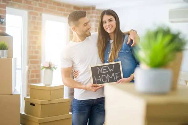 Belo jovem casal se mudando para uma nova casa, sorrindo muito feliz — Fotografia de Stock