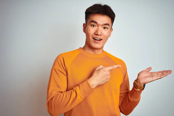 Joven Asiático Chino Hombre Usando Naranja Suéter Pie Sobre Aislado — Foto de Stock