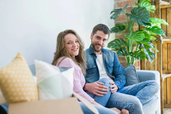 Junges verliebtes Paar umarmt sich auf dem Sofa sitzend sehr glücklich — Stockfoto