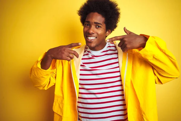 노란색 서있는 비옷을 아프리카 미국인 남성이 손가락 이빨과 입으로 가리키는 — 스톡 사진