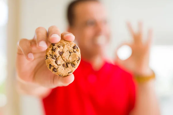 Mann Mittleren Alters Essen Schokoladenchips Kekse Hause Tun Zeichen Mit — Stockfoto