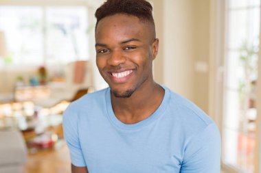 Büyük bir gülümseme ile neşeli gülümseyen yakışıklı Afrikalı genç adam 