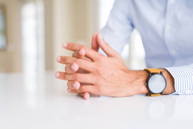 Beyaz masa üzerinde çapraz eller ile adam yakın