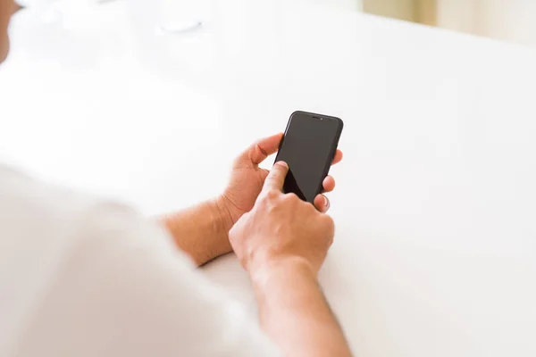 Primer plano de las manos de hombre de mediana edad utilizando el teléfono inteligente en casa —  Fotos de Stock