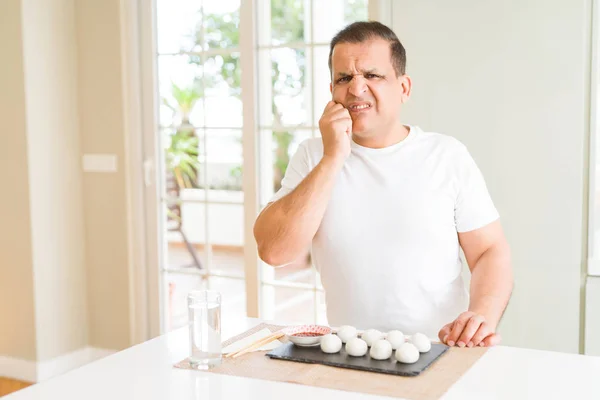 Hombre Mediana Edad Comiendo Albóndigas Asiáticas Casa Mirando Estresado Nervioso — Foto de Stock