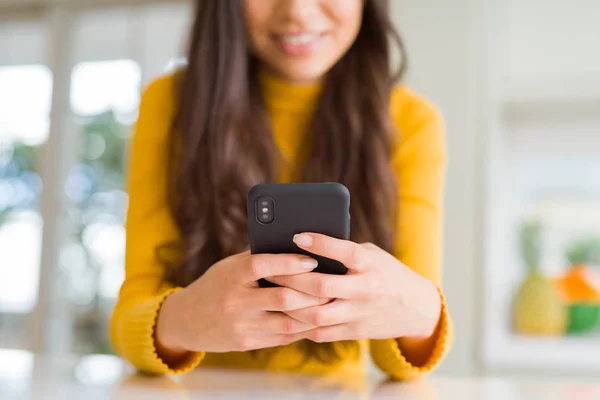 Закройте женские руки с помощью смартфона, улыбаясь — стоковое фото