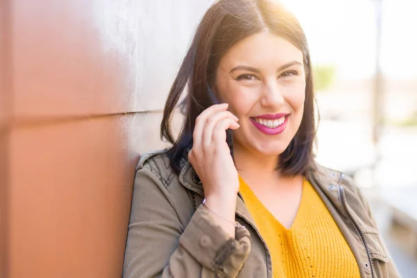 Schöne junge Frau lächelt positive Berufung mit Smarpthone — Stockfoto