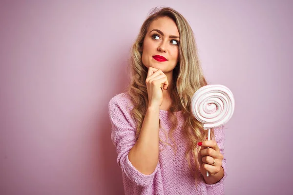 Młoda Piękna Kobieta Jedzenia Słodki Cukierek Ponad Różowy Białym Tle — Zdjęcie stockowe