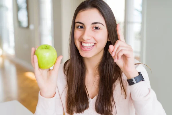 健康的な緑のリンゴの果実を食べる美しい若い女性は 幸せな顔で指を指すアイデアや質問に驚きました ナンバーワン — ストック写真