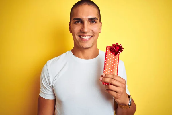 Joven Hombre Caucásico Sosteniendo Regalo Cumpleaños Sobre Fondo Aislado Amarillo —  Fotos de Stock