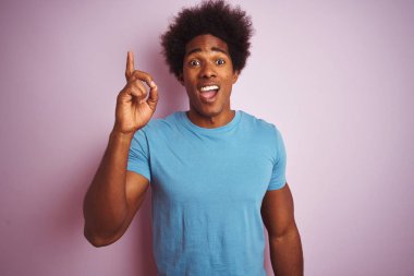Afro saçlı afro saçlı afro-amerikan adam izole pembe arka plan üzerinde duran başarılı bir fikir ile parmak işaret. Çıktı ve mutlu. Bir numara.