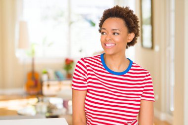 Genç güzel Afrikalı-Amerikalı kadın evde uzak tarafına yüzünde, doğal ifade gülümseme ile arıyorum. Kendine güvenen gülüyor.