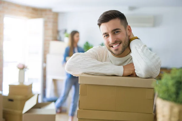 Pareja joven mudándose a un nuevo hogar, hombre guapo sonriendo inclinándose — Foto de Stock