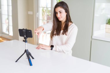 Kamera ve size parmak la işaret akıllı telefon web kamerası ile selfie video kayıt güzel genç kadın, el işareti, önden olumlu ve kendinden emin jest