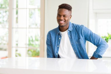 Yakışıklı afro-amerikan adam evde göz kırpıyor seksi ifade ile kameraya bakarak, neşeli ve mutlu yüz.