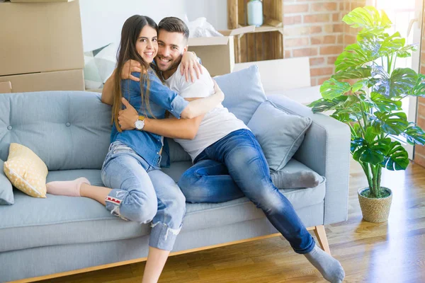Schönes Paar, das sich verliebt auf dem Sofa umarmt, sehr glücklich lächelnd — Stockfoto
