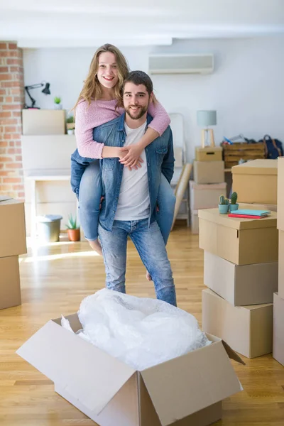 Pareja joven mudándose a una casa nueva, novio dando un bac cerdito — Foto de Stock