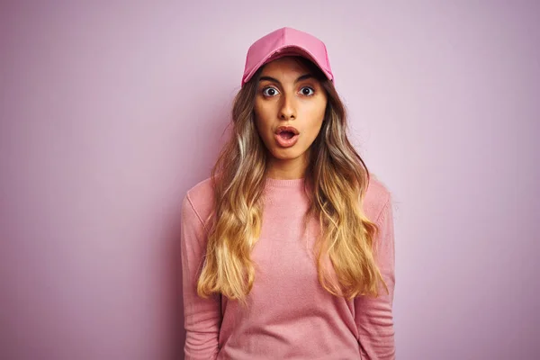 年轻美丽的女人戴帽子在粉红色孤立的背景害怕和震惊与惊喜的表情 恐惧和兴奋的脸 — 图库照片