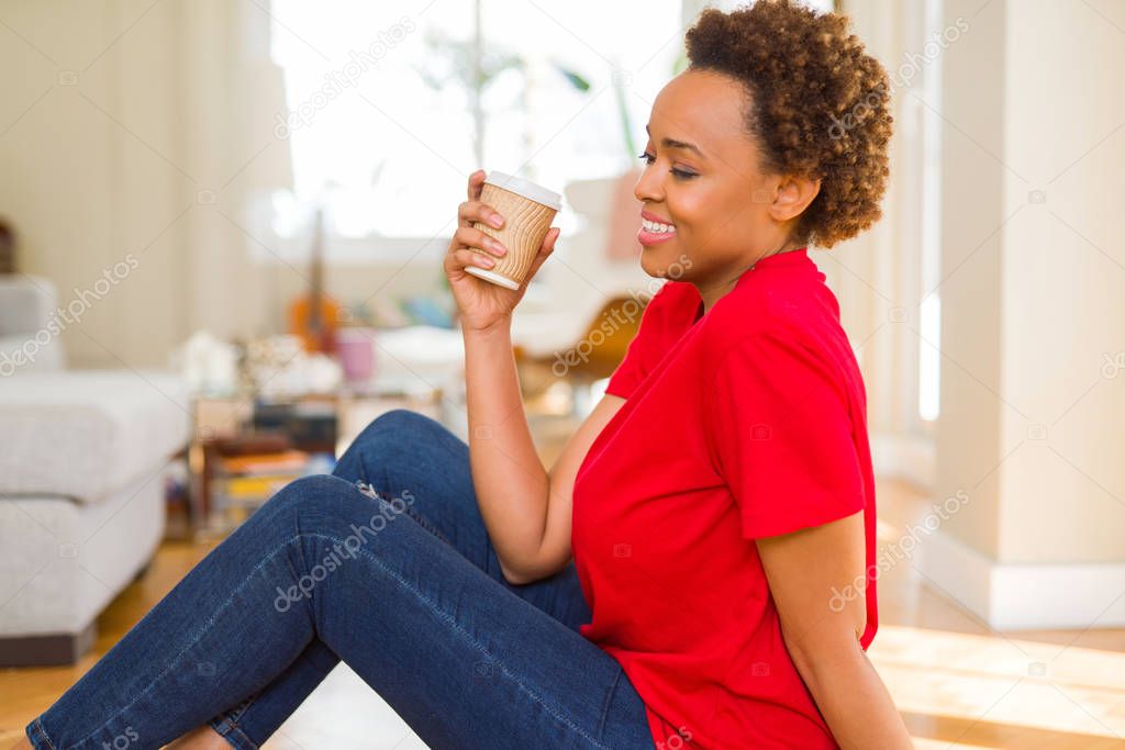 Beautiful young african american woman drinking a coffee in a ta