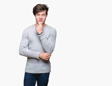 Emin çapraz kollar ve çeneme kaldırdı el ile gülümseme ile kameraya bakarak izole arka plan üzerinde kış kazak giyen genç yakışıklı adam. Pozitif düşünce.