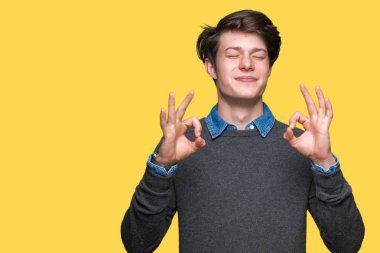 Genç yakışıklı zarif adam izole arka plan üzerinde dinlenmek ve gülümseyen gözlerle parmak ile meditasyon jest yapıyor kapalı. Yoga kavramı.