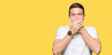 Yakışıklı adam ağız hata için elleriyle kapsayan şok Casual beyaz t-shirt giyiyor. Gizli kavramı.