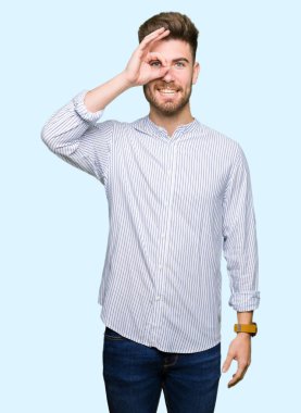 Genç yakışıklı adam el hareketleriyle gülümsüyor, gözleriyle mutlu yüzüyle parmaklarından bakıyor..