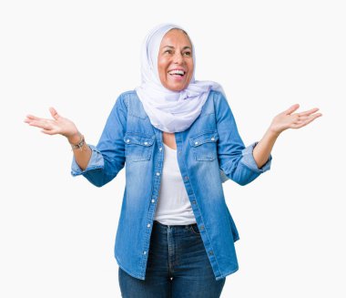 Eller izole arka plan gülen gösteren üzerinde her iki Arap hijab giyen orta yaş Doğu Arap kadın açık avuç içi, sunmak ve reklam karşılaştırma ve denge