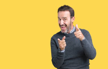 Yakışıklı orta yaş üst düzey fotoğraf makinesi ile mutlu ve komik yüz için parmakları işaret izole arka plan üzerinde bir kazak giyen adam. İyi enerji ve vibes.