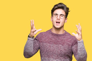 Üzerinde gözlük takan genç yakışıklı adam arka plan deli izole ve deli bağırarak ve agresif ifade ve silah kaldırdı bağırıyor. Hayal kırıklığı kavramı.