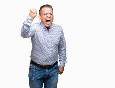 Orta yaş Arap iş adamı izole arka plan öfkeli ve sinirli sinirli ve öfke ile bağırarak süre öfkeli yumruk yükselterek üzerinde. Öfke ve agresif kavramı.