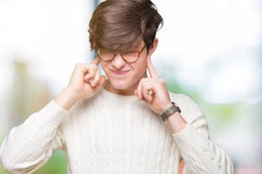 Yüksek sesle müzik gürültü rahatsız ifade parmaklarıyla kulaklarıyla kapsayan izole arka plan üzerinde gözlük takan yakışıklı delikanlı. Sağır kavramı.