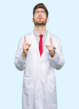 Gözlüklü genç yakışıklı bilim adamı şaşırtmak ve yukarıya bakıp parmakları ile işaret şaşırttı ve silah kaldırdı.