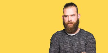 Genç sarışın adam rahat kazak şüpheci ve sinir, onaylamayan ifade yüz çapraz kollu giyiyor. Negatif kişi.