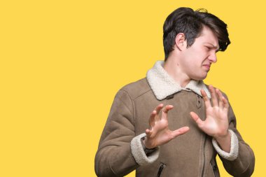 İzole arka plan üzerinde kış ceket giyen genç yakışıklı adam tiksinti ifadesi, memnun ve korkulu tiksinti yüz yapıyorsun çünkü nefret tepki. Elleriyle kaldırdı. Sinir bozucu kavramı.